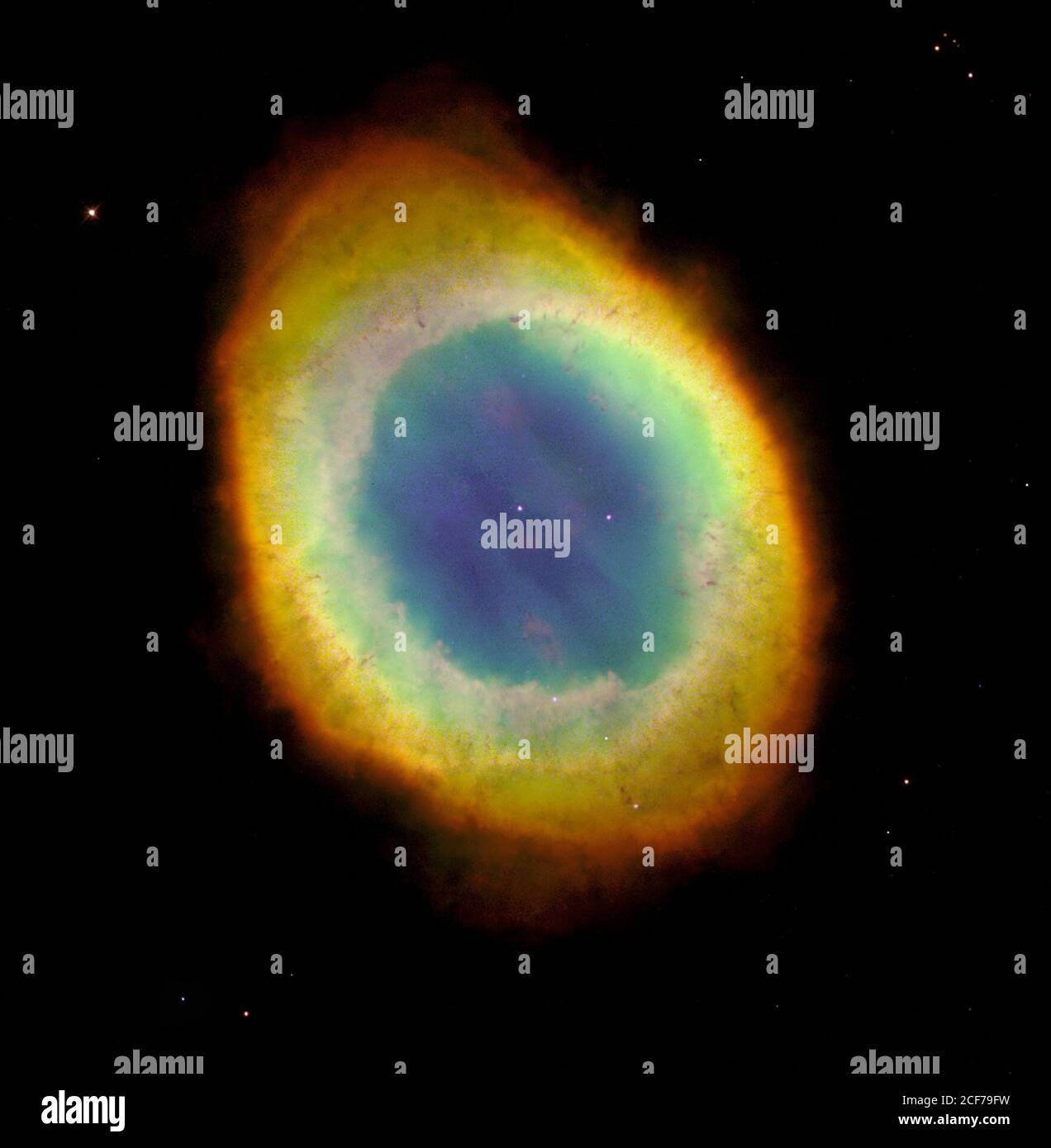 The NASA Hubble Space Telescope has captured the sharpest view yet of the most famous of all planetary nebulae, the Ring Nebula (M57). In this October 1998 image, the telescope has looked down a barrel of gas cast off by a dying star thousands of years ago. This photo reveals elongated dark clumps of material embedded in the gas at the edge of the nebula; the dying central star floating in a blue haze of hot gas. The nebula is about a light-year in diameter and is located some 2,000 light-years from Earth in the direction of the constellation Lyra. The colors are approximately true colors. The Stock Photo
