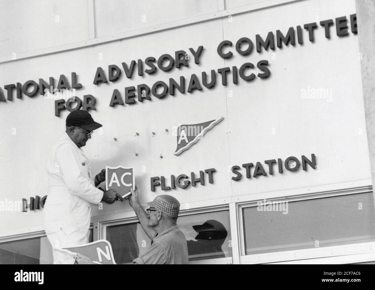 Dahl Matay and John Hedgepeth Sr. change the NACA sign to NASA at the Flight Research Center. Oct./Nov. 1958 NASA DFRC E96-43403-04 (copy neg) Stock Photo