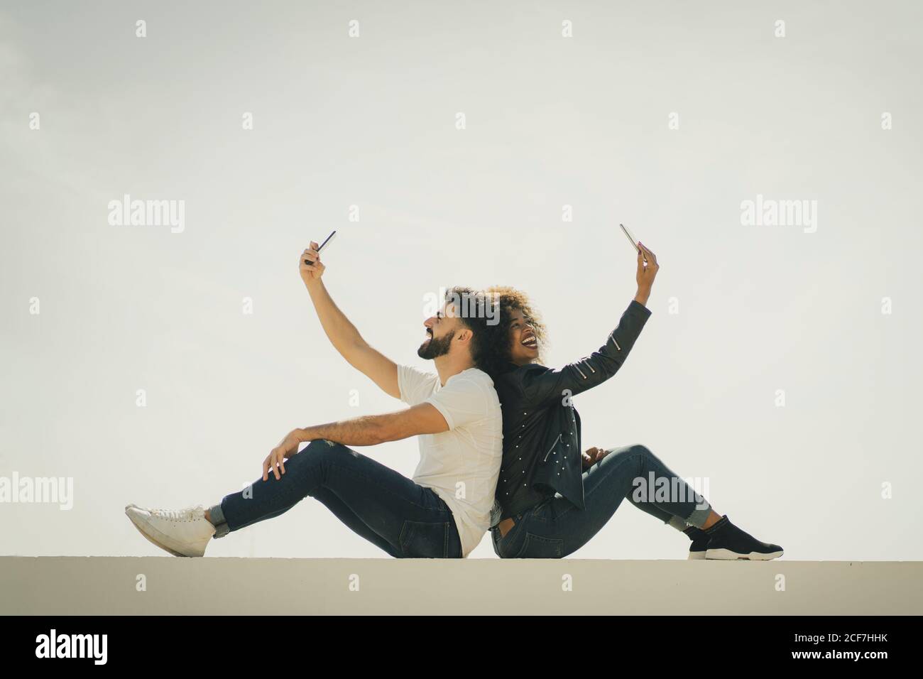 Back view woman sitting on wall hi-res stock photography and images - Alamy