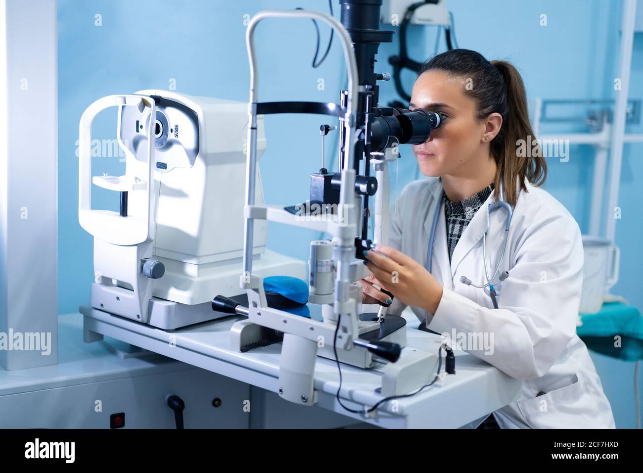 Young medical worker looking and using microscope at workplace on blurred background Stock Photo