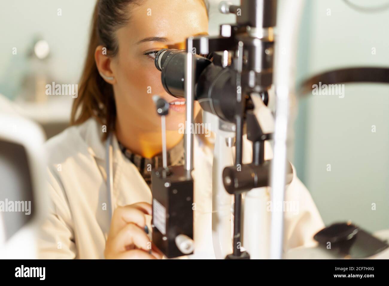 Young medical worker looking and using microscope at workplace on blurred background Stock Photo