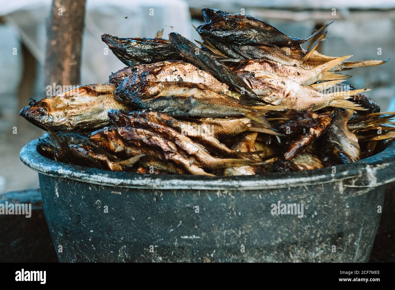 Shabby bowl with smelly dried fish placed on street market in Gambia Stock Photo