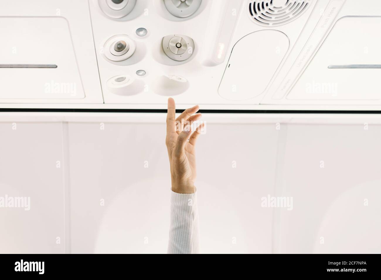 person pressing button on panel up airplane Stock Photo