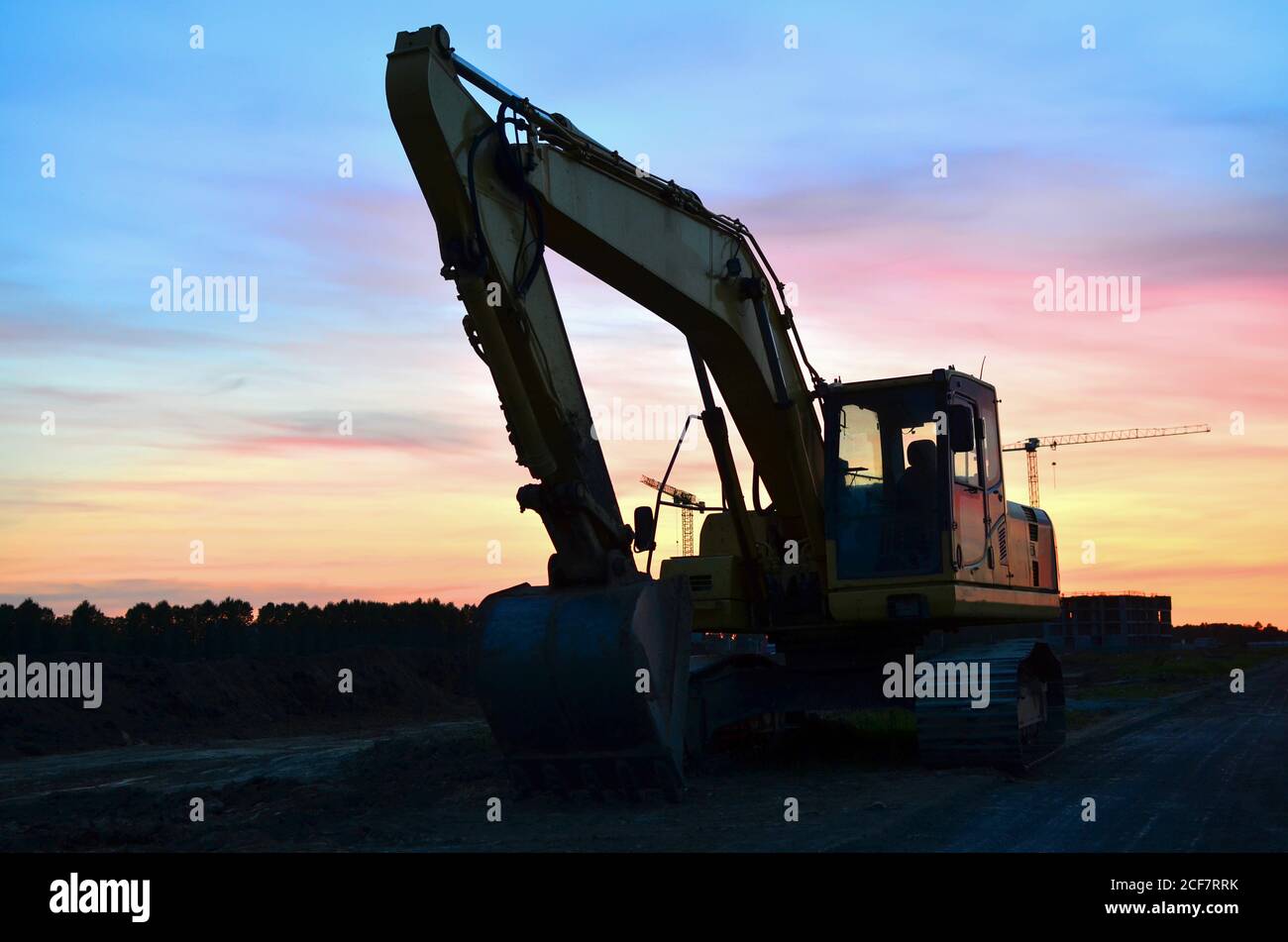 Excavator at construction site on sunset background. Earth-moving heavy ...