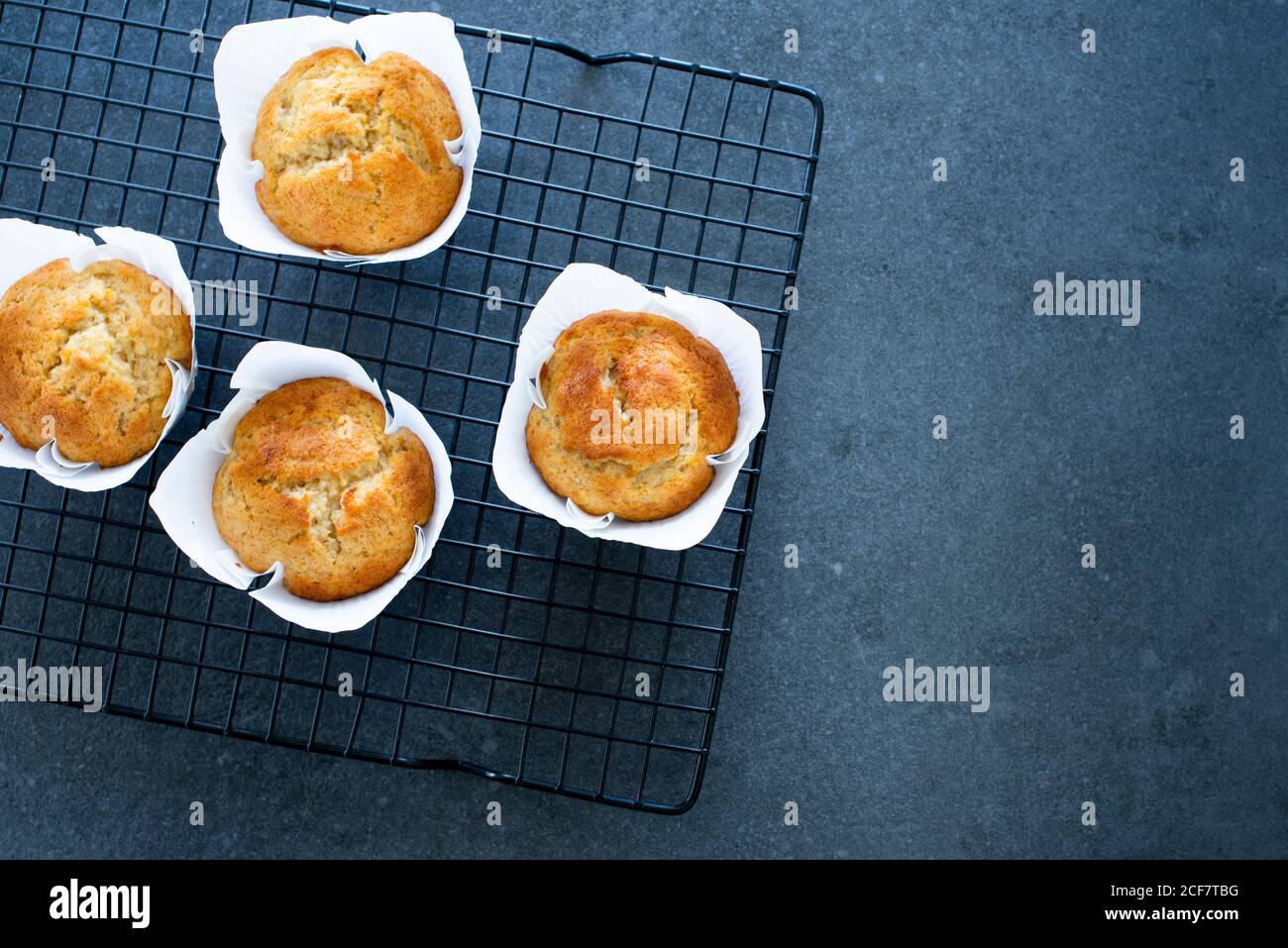 Freshly baked homemade banana muffins on wire cake rack, flat lay with copy space Stock Photo