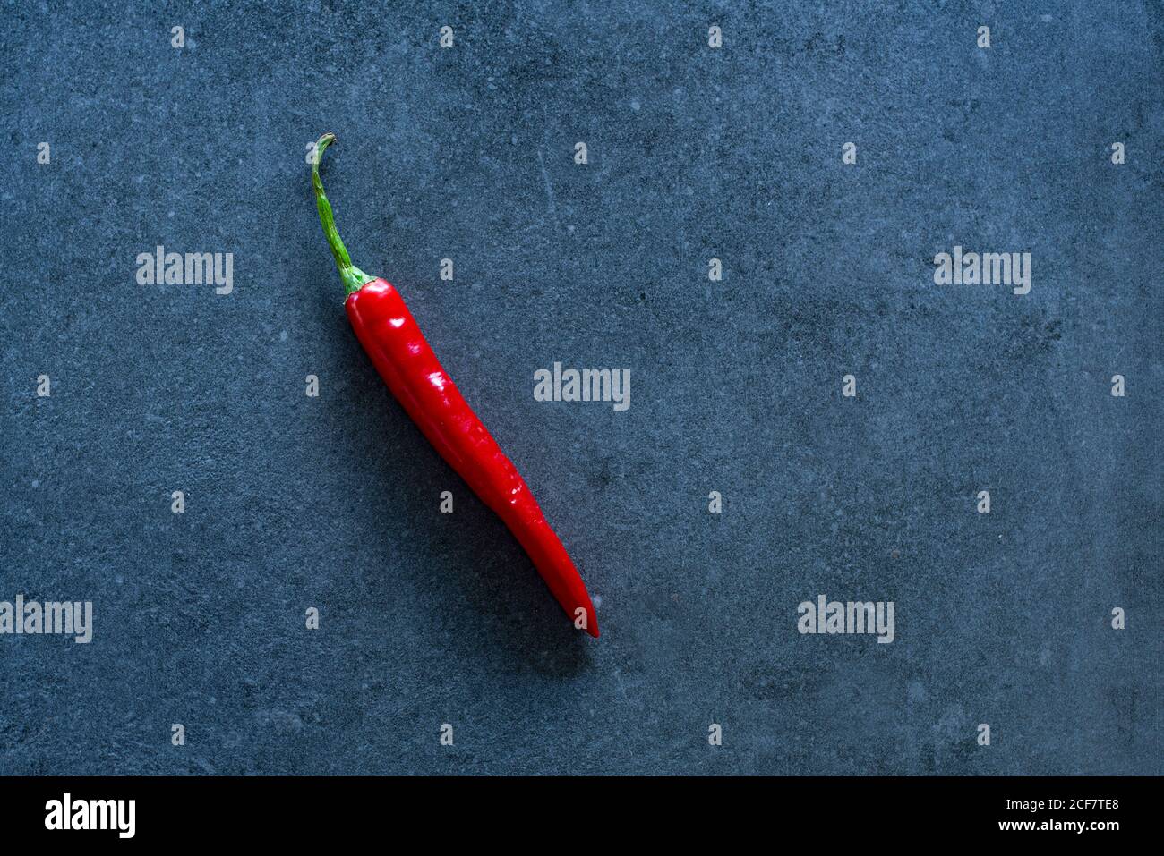 Red hot chilli pepper on dark background, flat lay with copy space Stock Photo