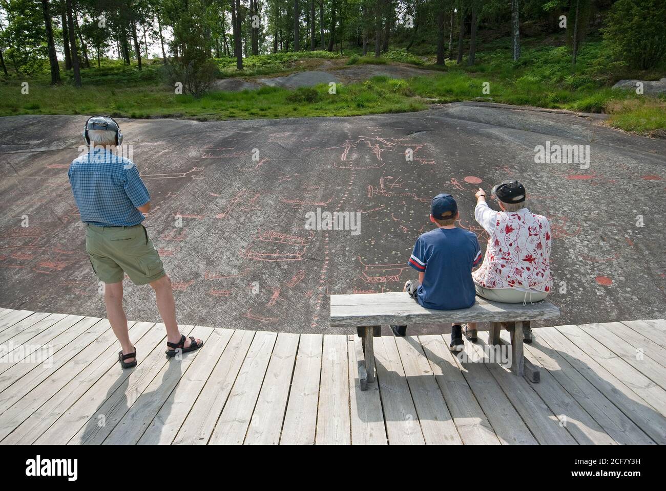 Visitors watching petroglyphs at the archaeological site of Tanumshede (Unesco World Heritage Site), County, Sweden Stock Photo
