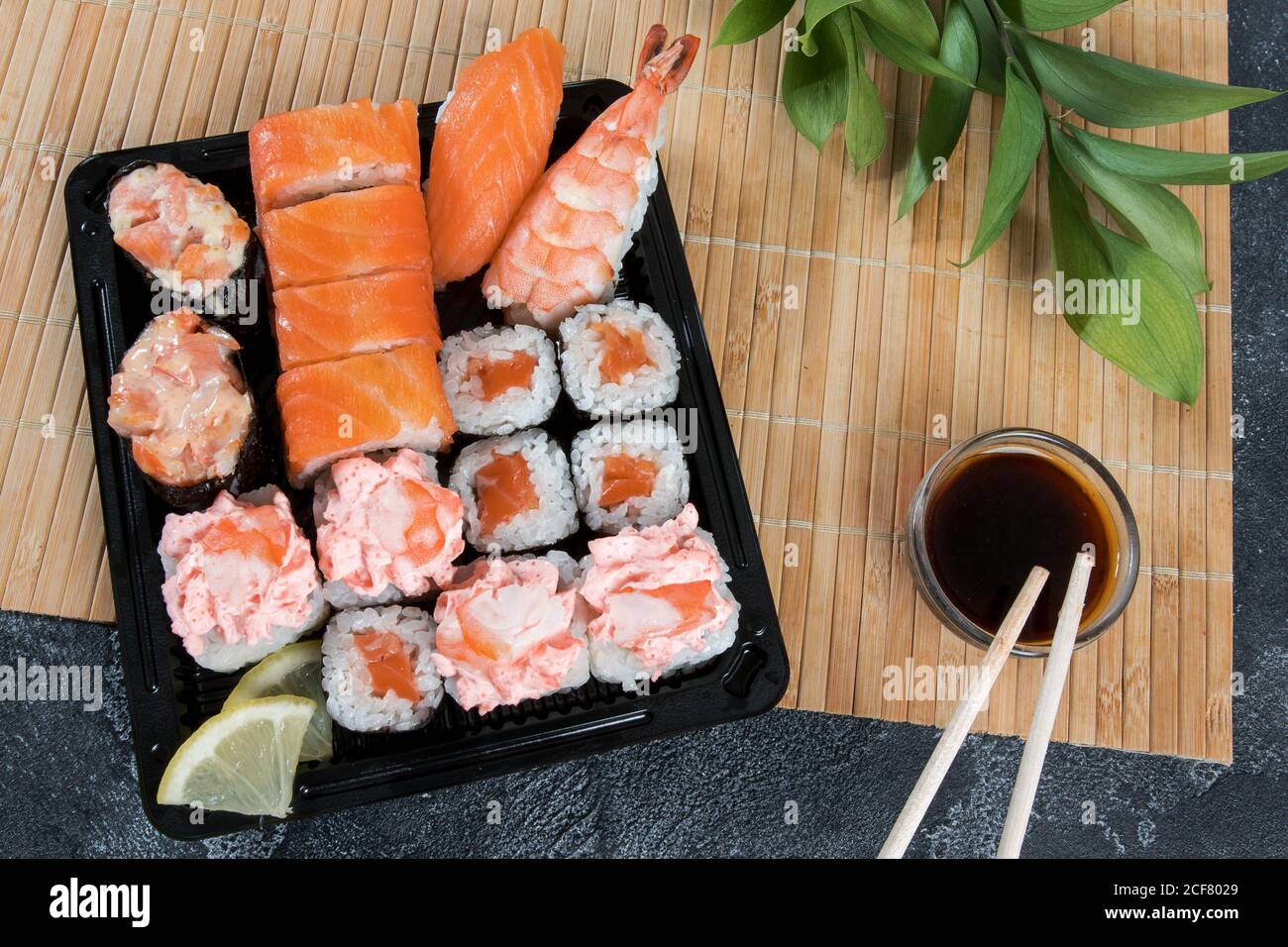 Sushi delivery box with maki, gunkan, nigiri sushi and wooden sticks with soy. Food delivery concept background Stock Photo