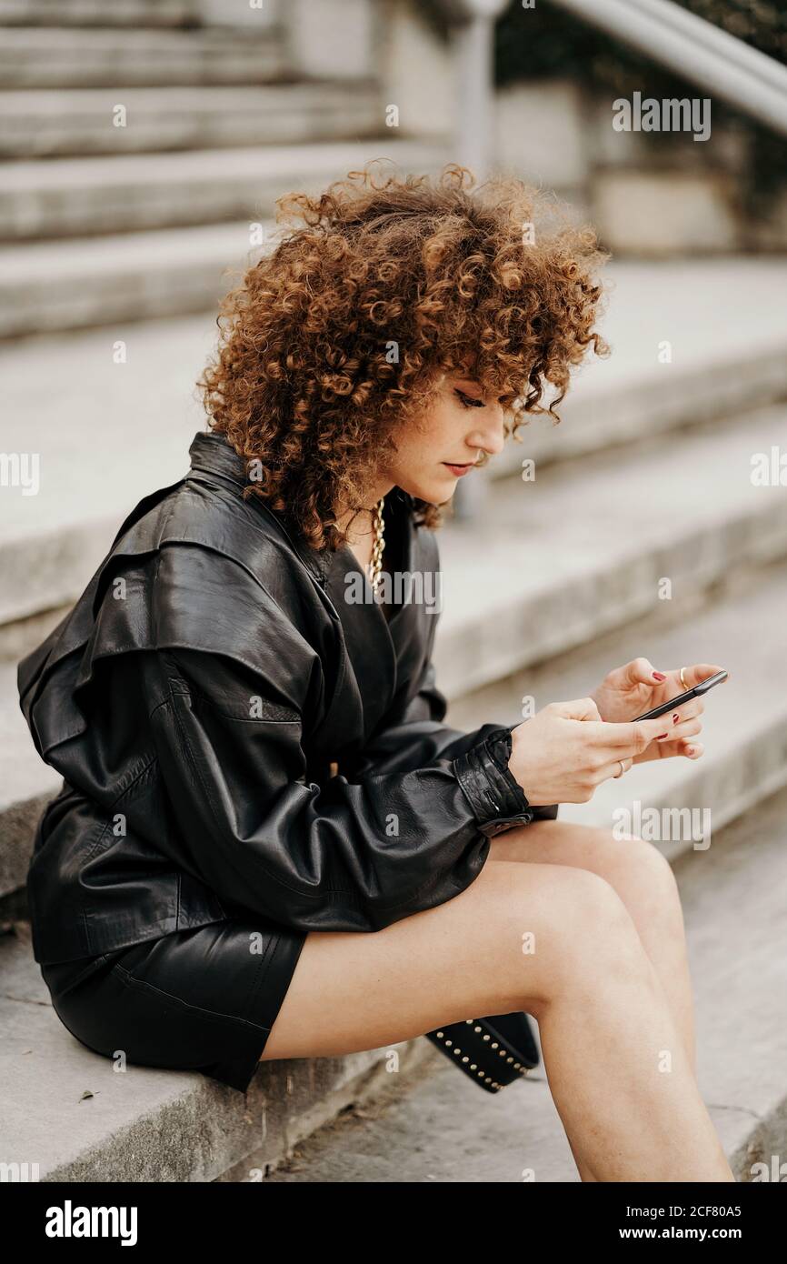 Retro businessWoman using smartphone on stairs Stock Photo