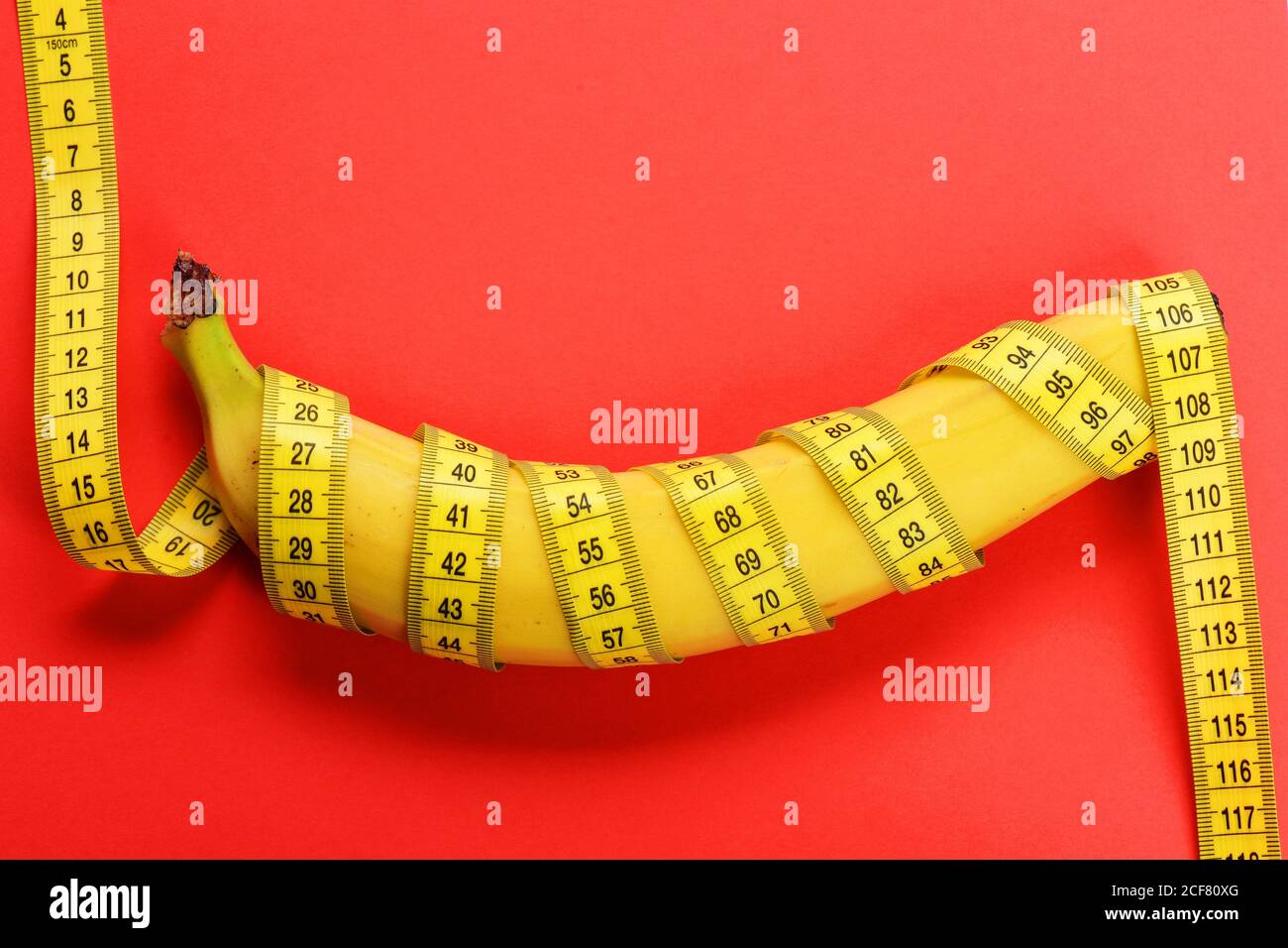 Banana with yellow tape for measuring figure. Rolled centimeter ruler
