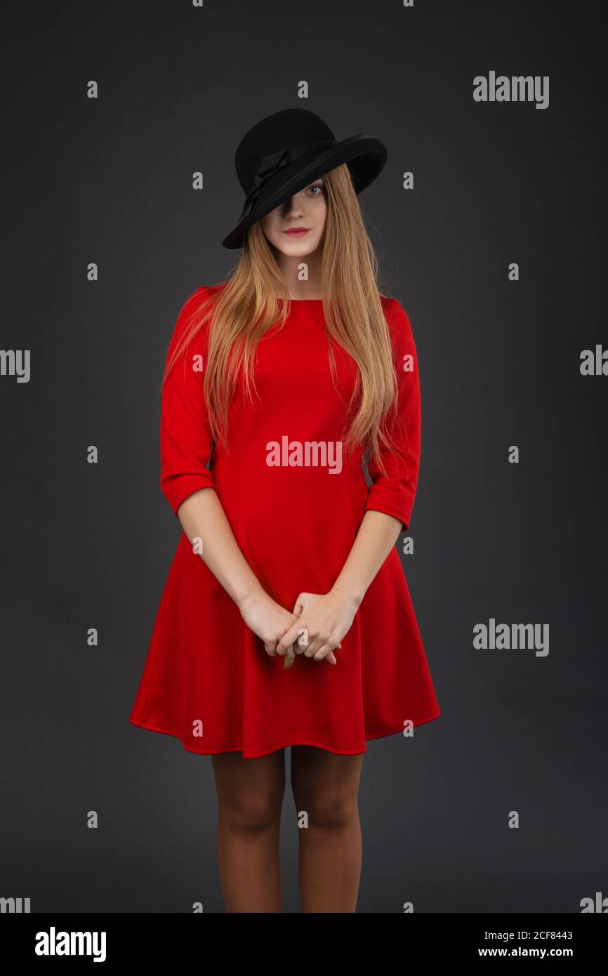 A beautiful girl in red dress and black felt hat Stock Photo - Alamy