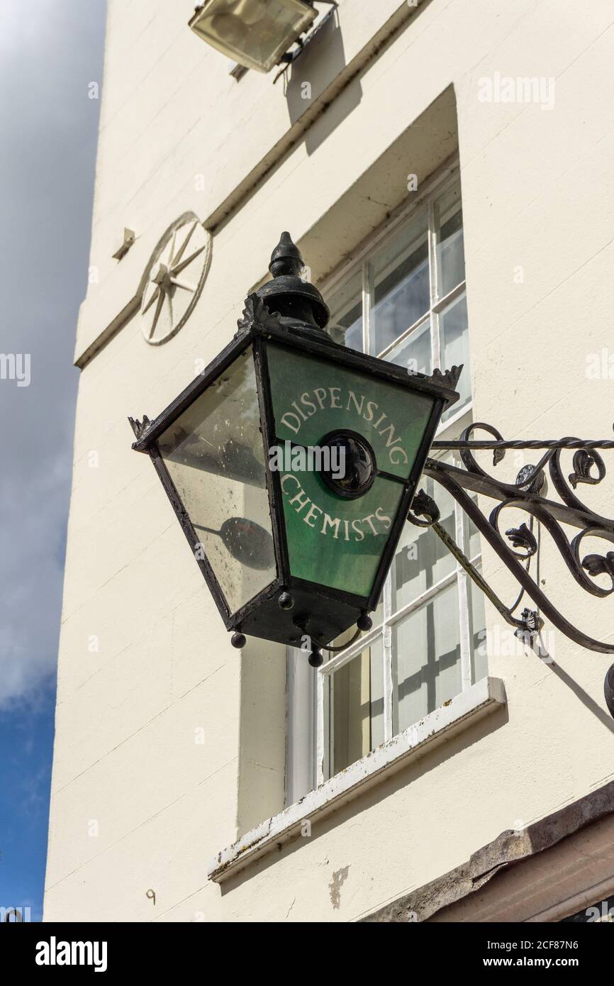 Ornate metal wall mounted lamp, with the words dispensing chemist, outside Cox and Robinson Pharmacy, Stony Stratford, UK Stock Photo