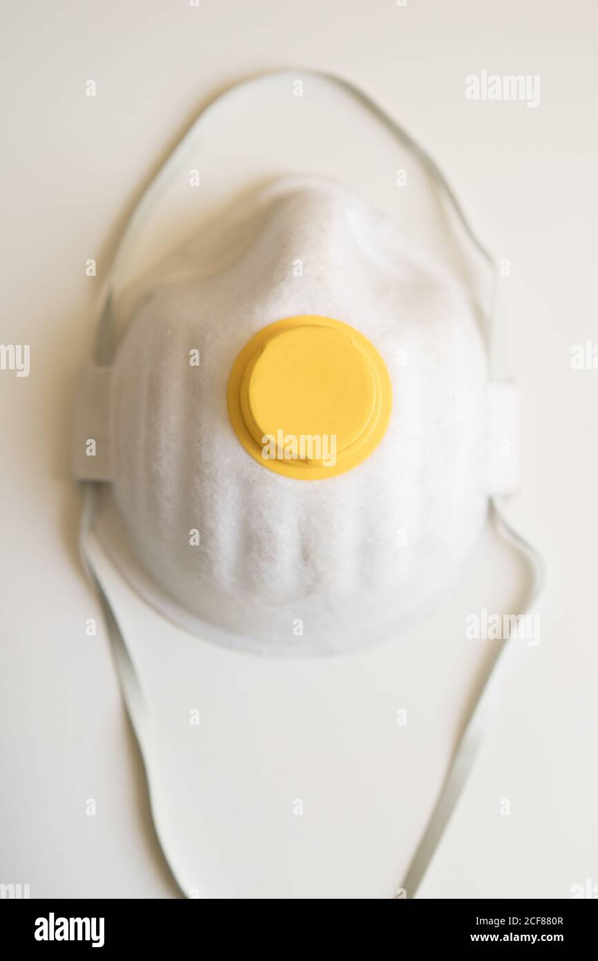 From above of facial protection mask placed on white background isolated as symbol of protection against coronavirus pandemic and other infections Stock Photo