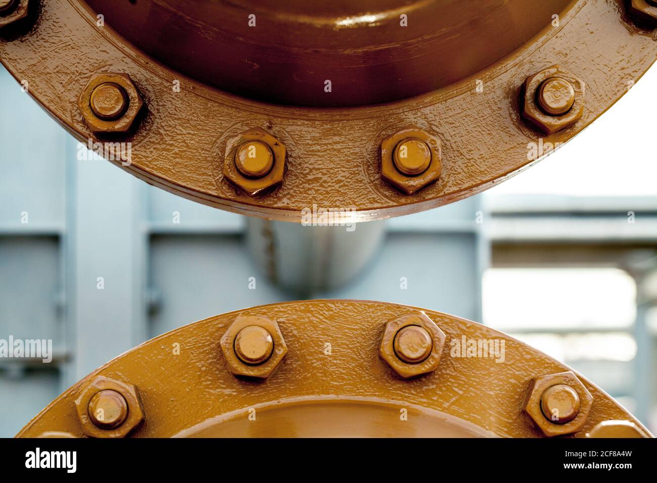 Closeup of steel joint connecting flanges with bolts and nuts on pipe transferring liquids at factory Stock Photo