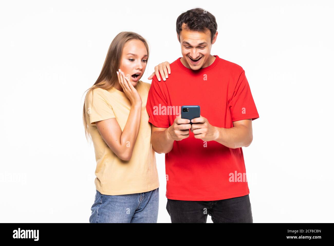 Young man and surprised woman are watching on the phone on white ...