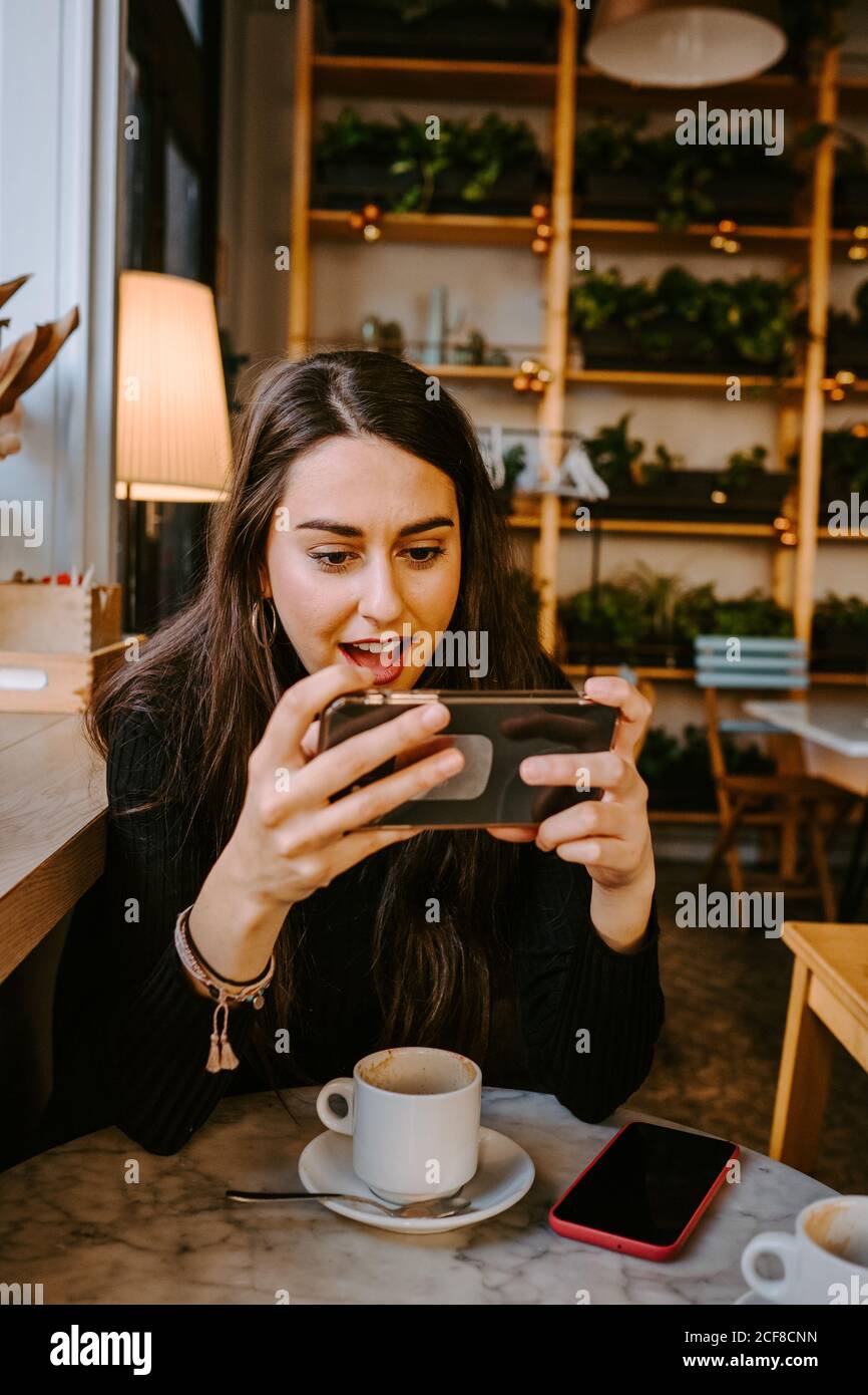 Young lady using smartphone in cafe Stock Photo