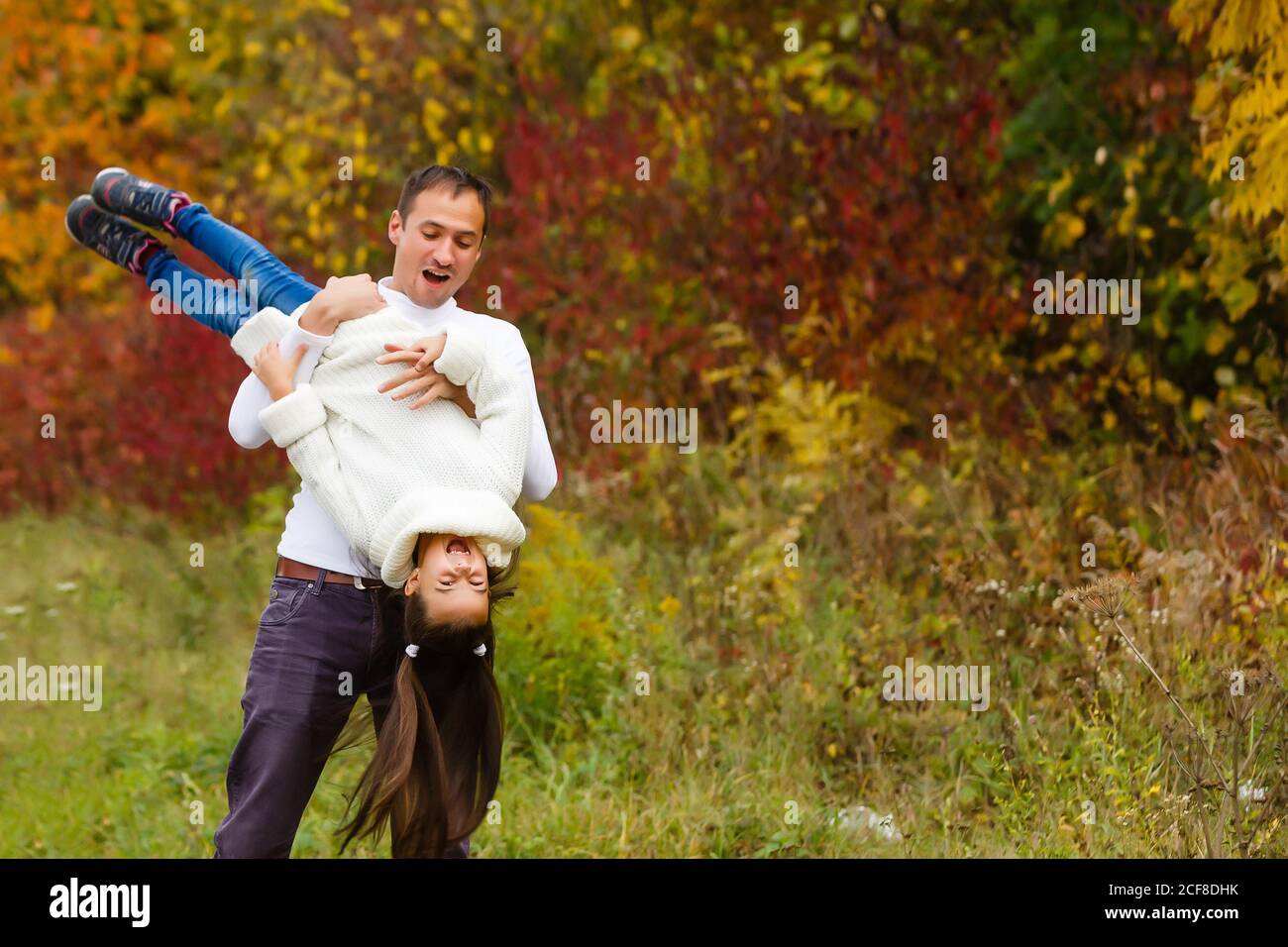 father and daughter having a fun in autumn park Stock Photo - Alamy
