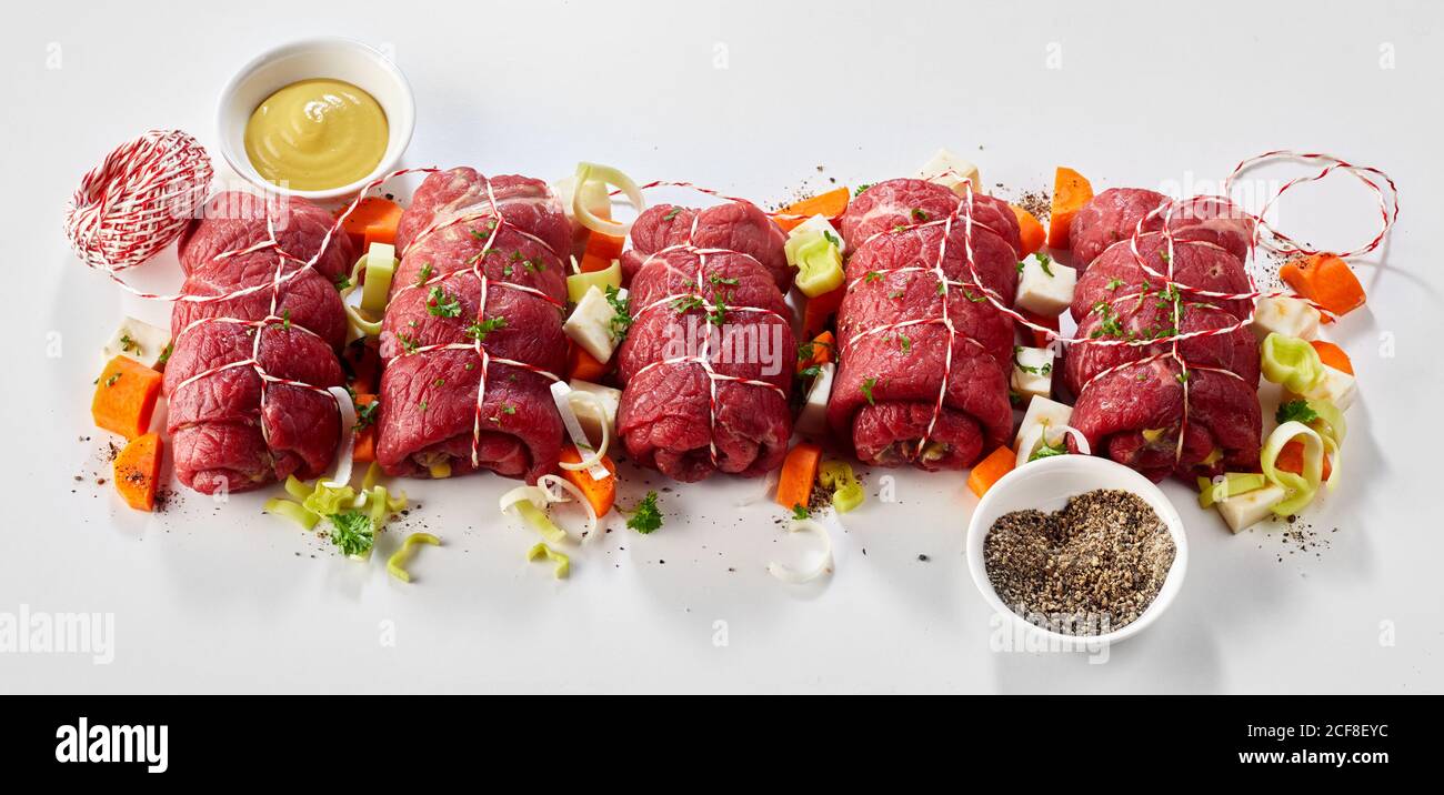 Ingredients and trimmings for beef roulades viewed as a flat lay still