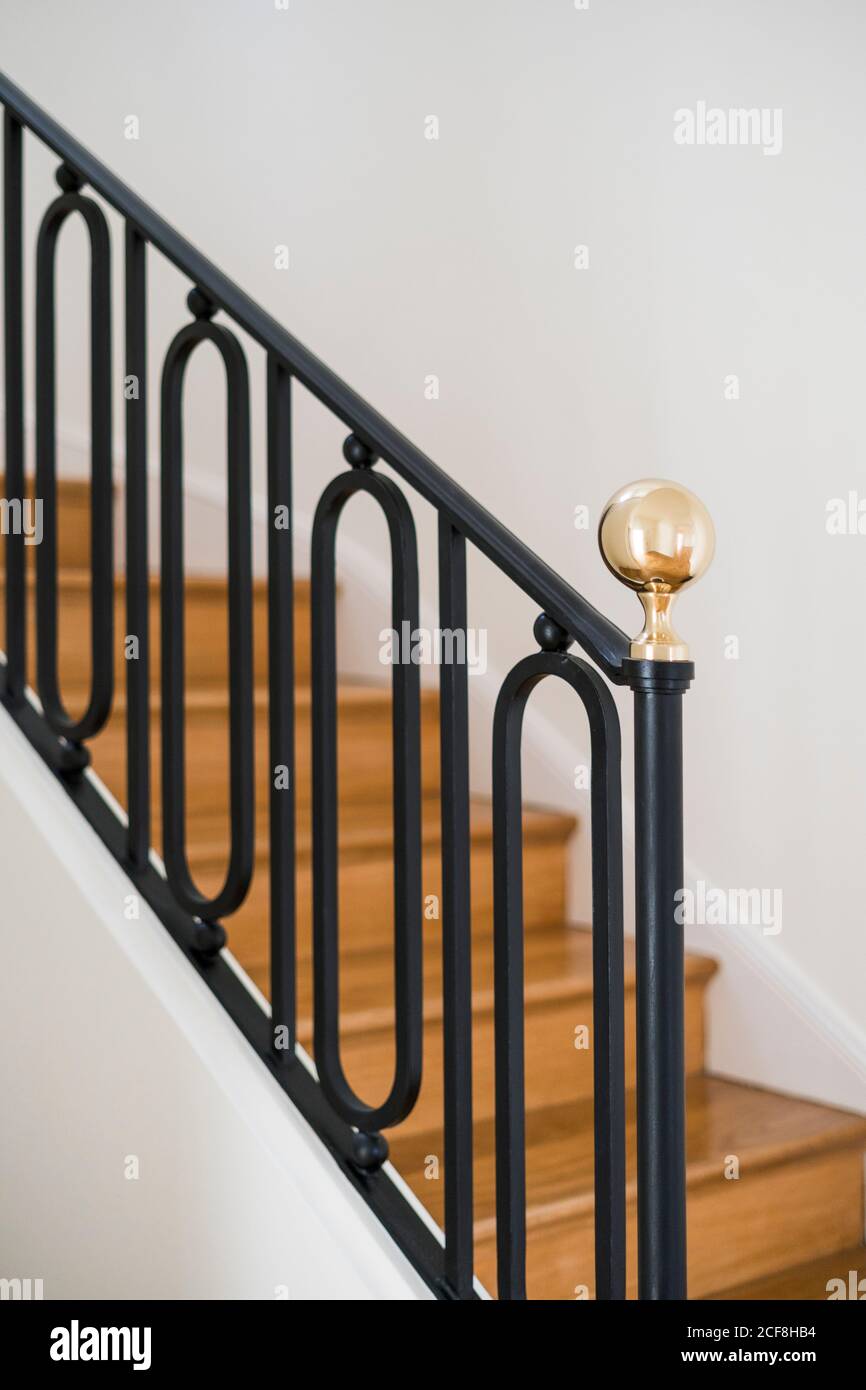 Solid wooden staircase with black railing in house with light interior ...