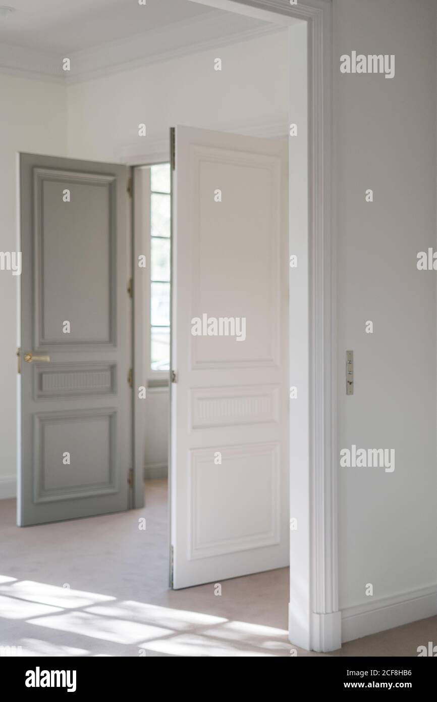 Open bicolor swing door with modern handle in white minimalistic interior Stock Photo