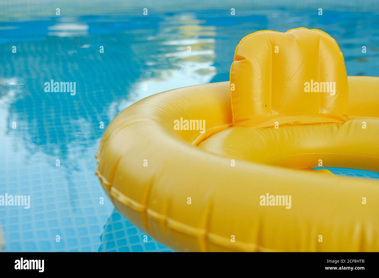 Close-up of a yellow inflatable ring for babies in the water in the pool. Goods for the rest of the kids. Partial blur Stock Photo