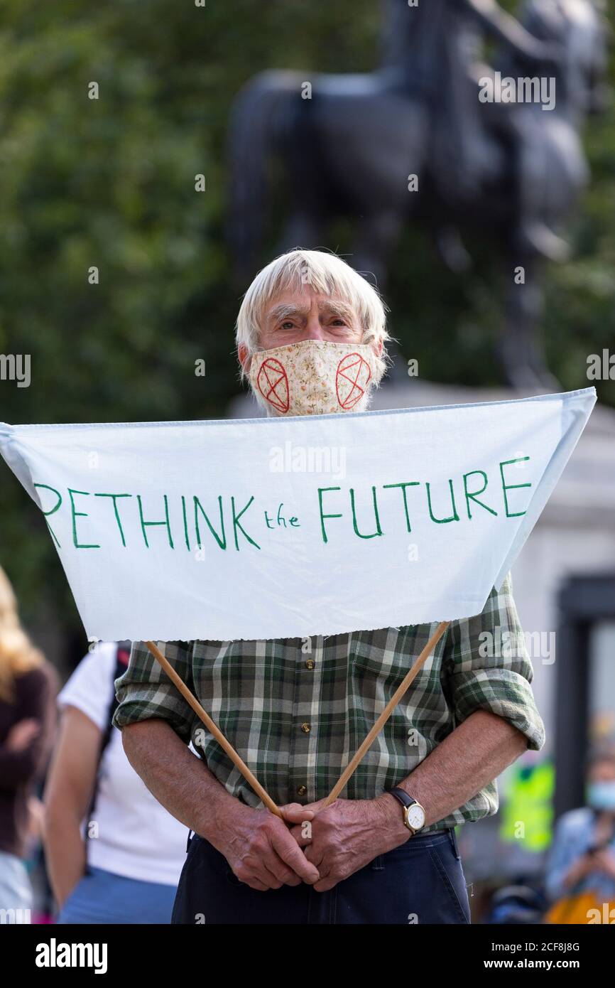 An elderly protester with a banner during Extinction Rebellion demonstration, Parliament Square, London, 1 September 2020 Stock Photo
