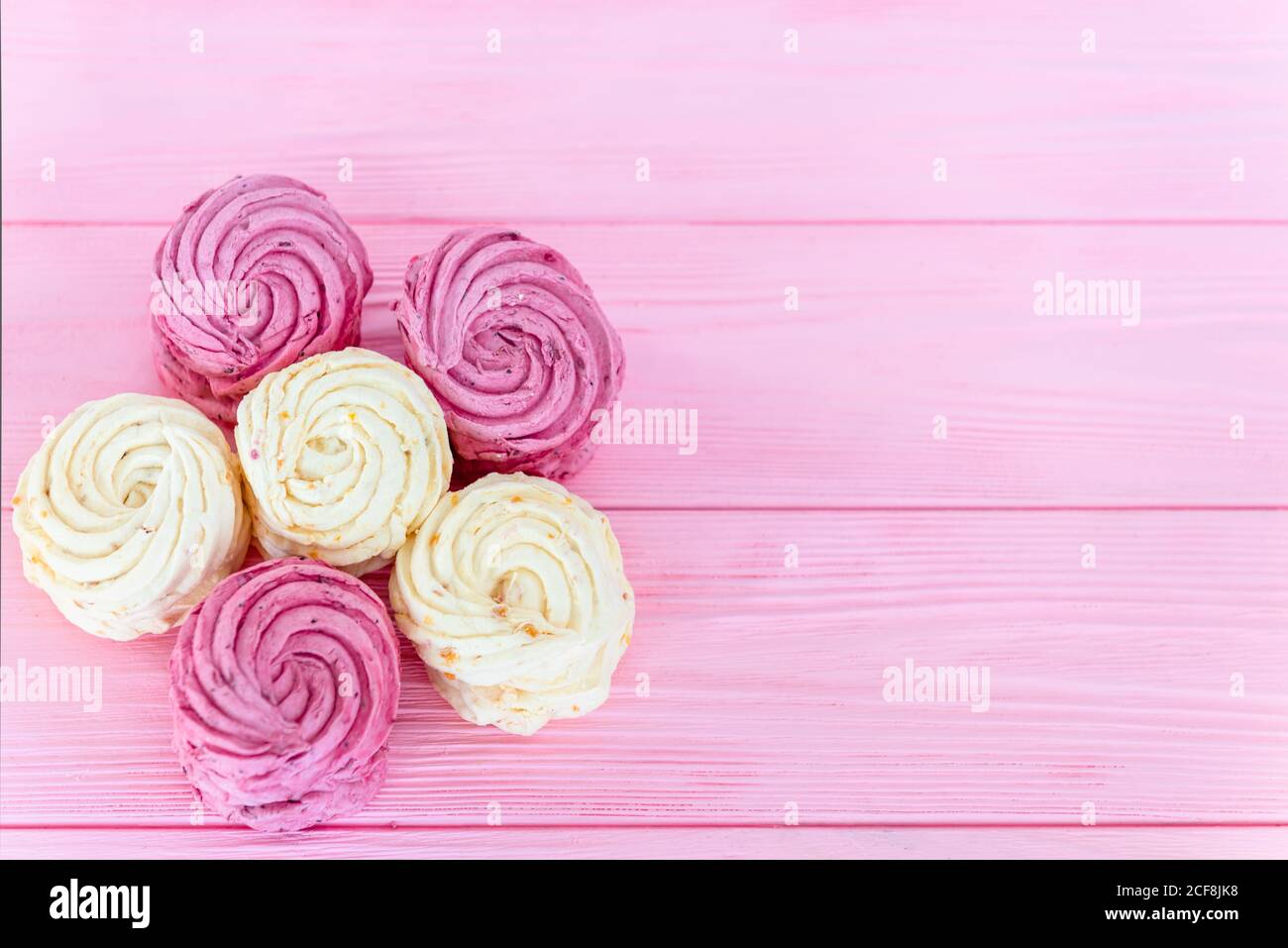 Apple and raspberry zephyr on pink background. Sweet confectionery. Stock Photo