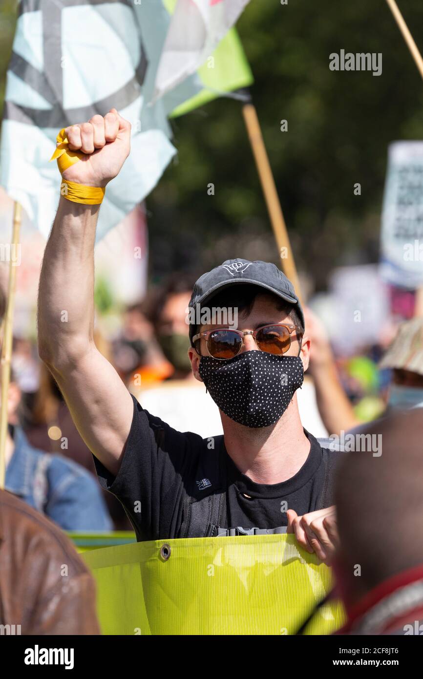 A marching protester with his fist raised during Extinction Rebellion demonstration, London, 1 September 2020 Stock Photo