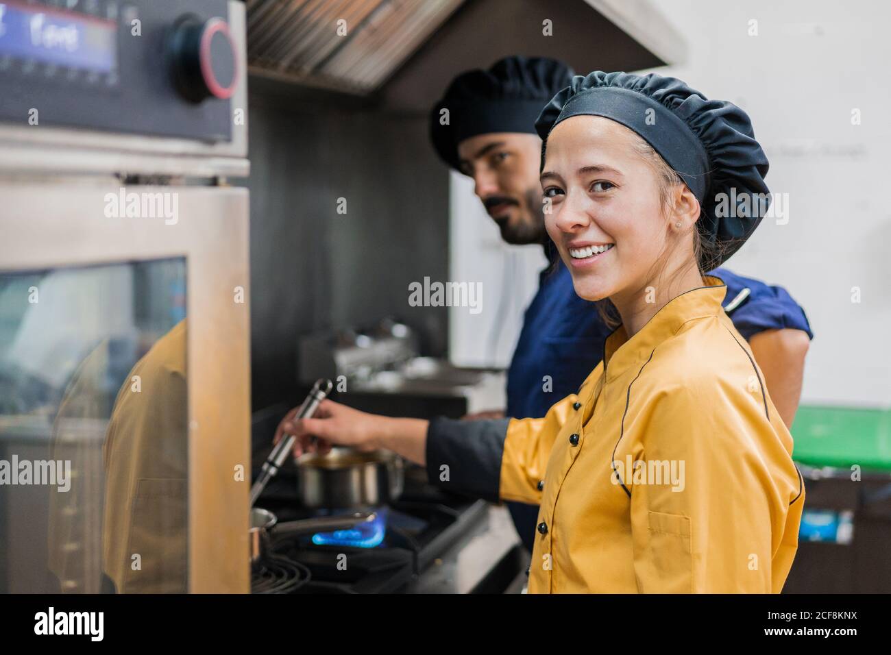 Professional chef and assistant working in kitchen Stock Photo