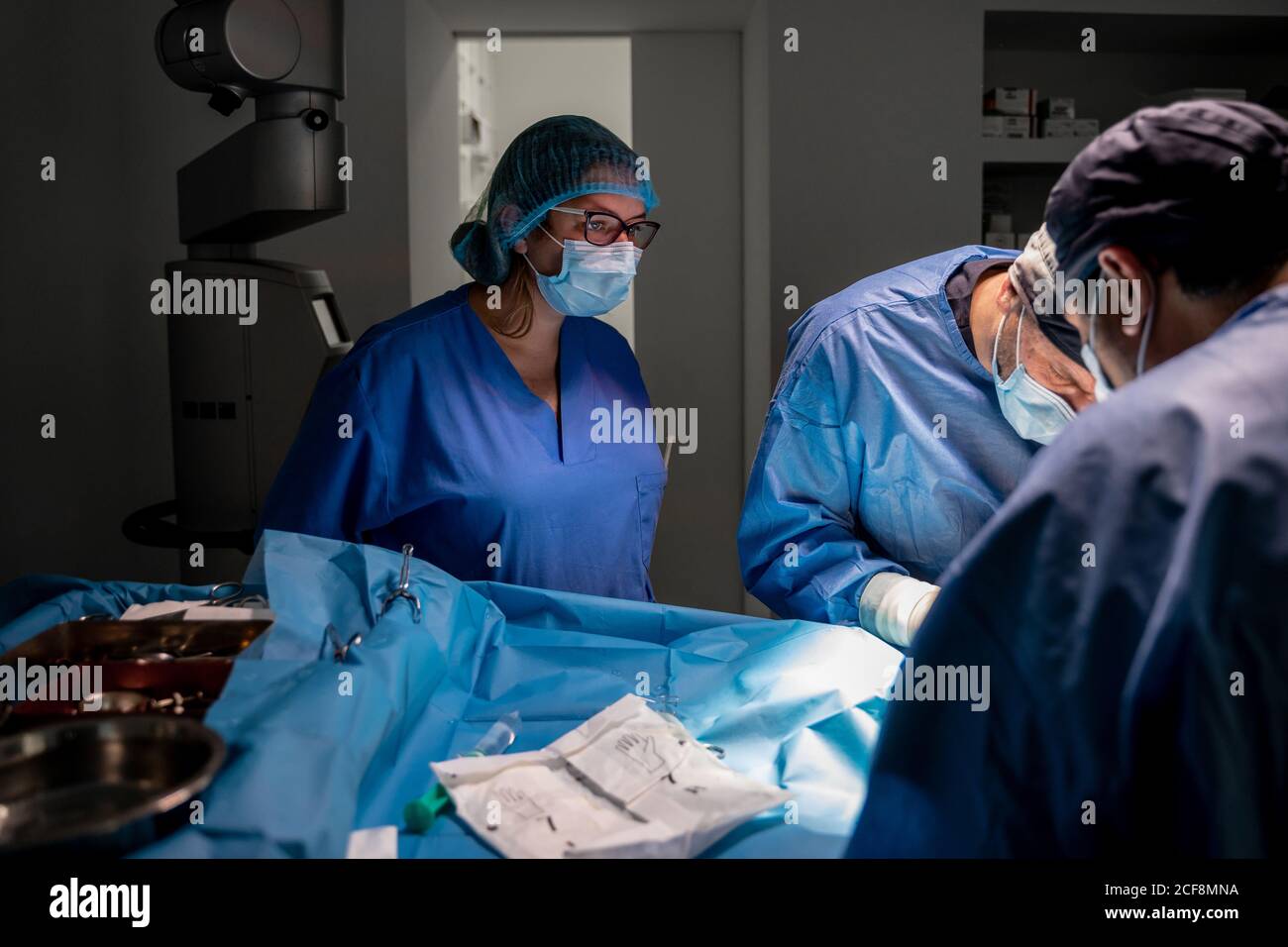 Surgeons and nurses in uniform concentrating and operating patient