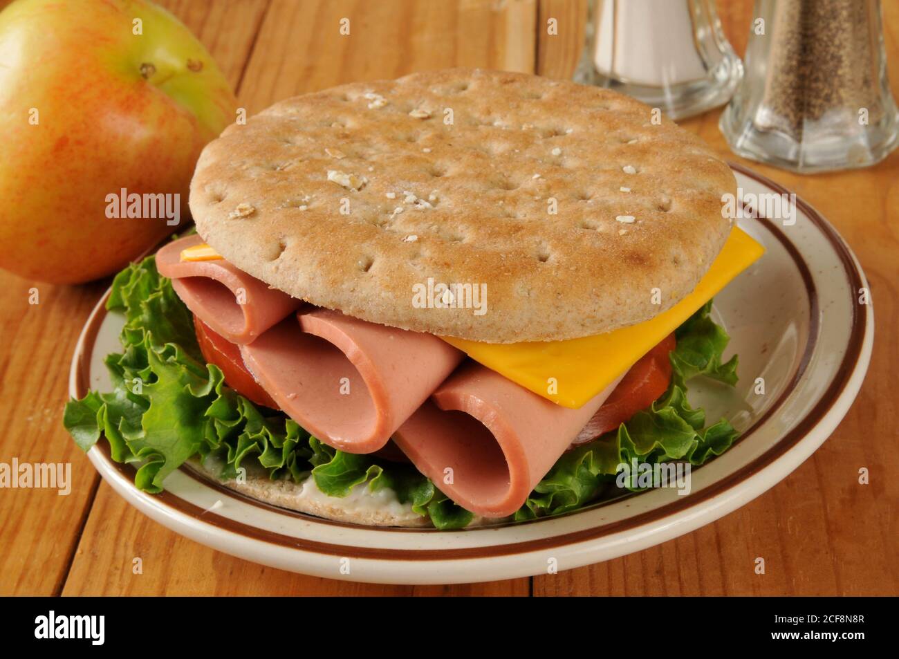 A bologna and cheese sandwich on thin round sandwich bread Stock Photo