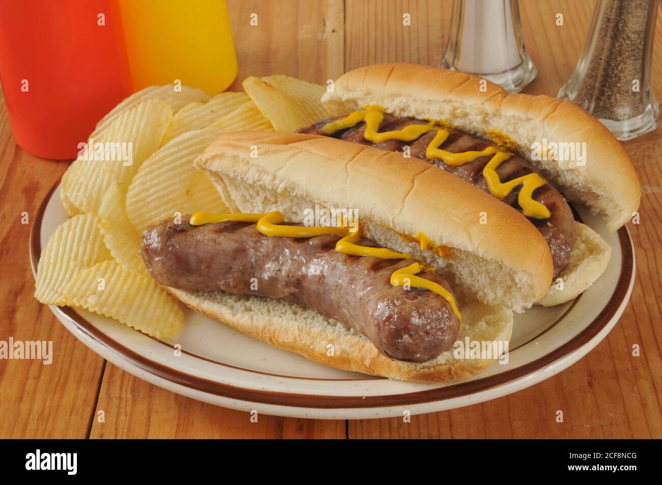 Bratwurst with mustard and potato chips Stock Photo Alamy