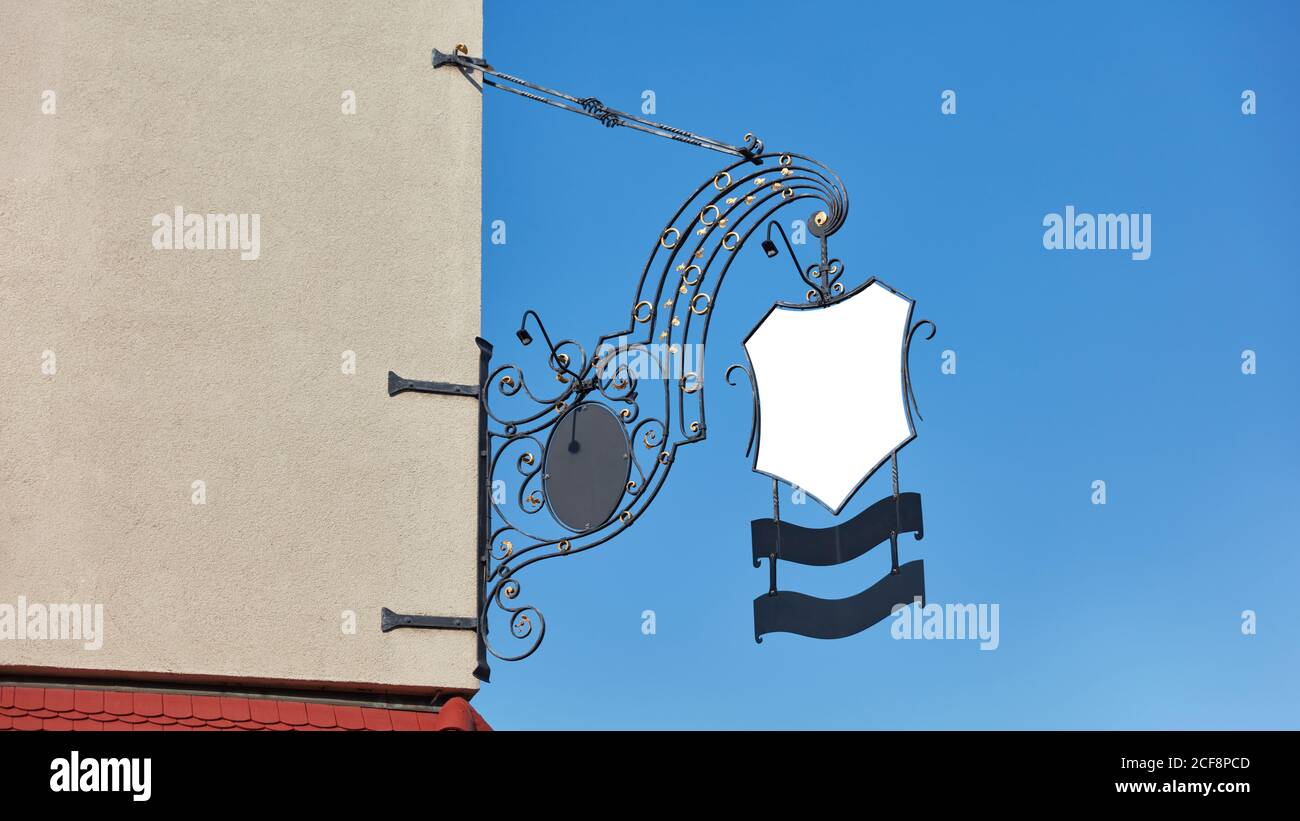 Old-fashioned blank white pub sign as a mock-up template on a house ...