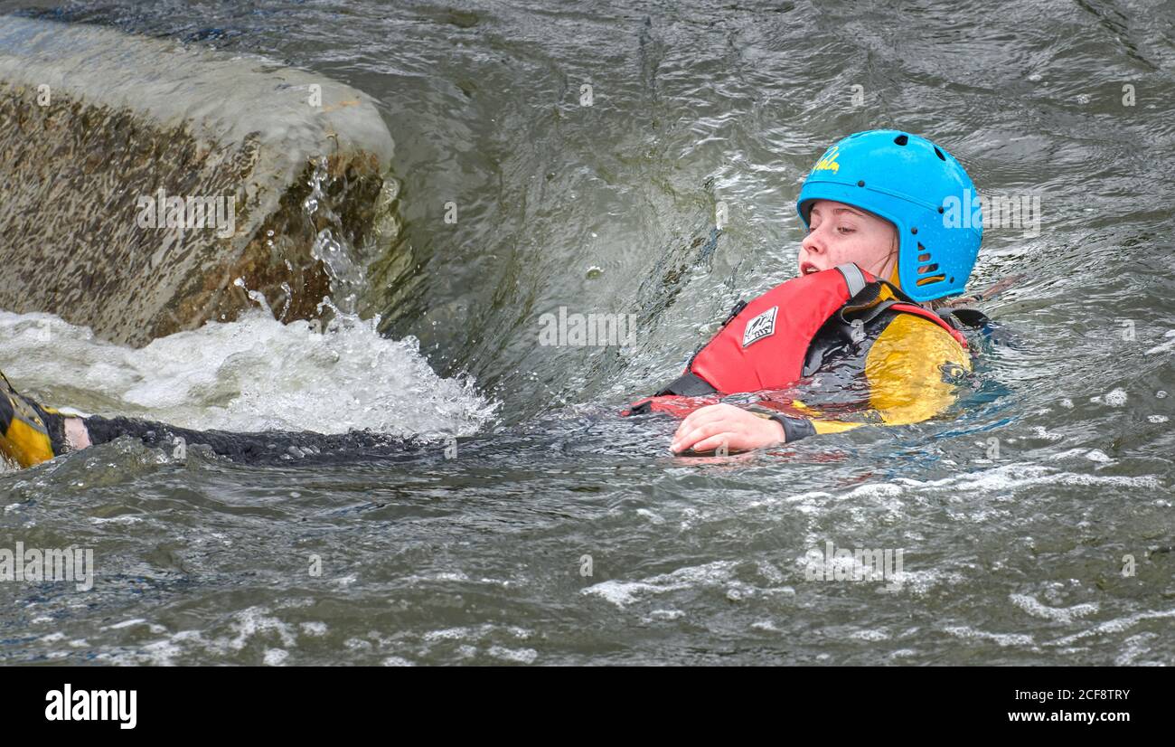 An adolescent girl floats downstream on her back at the Nene artificial
