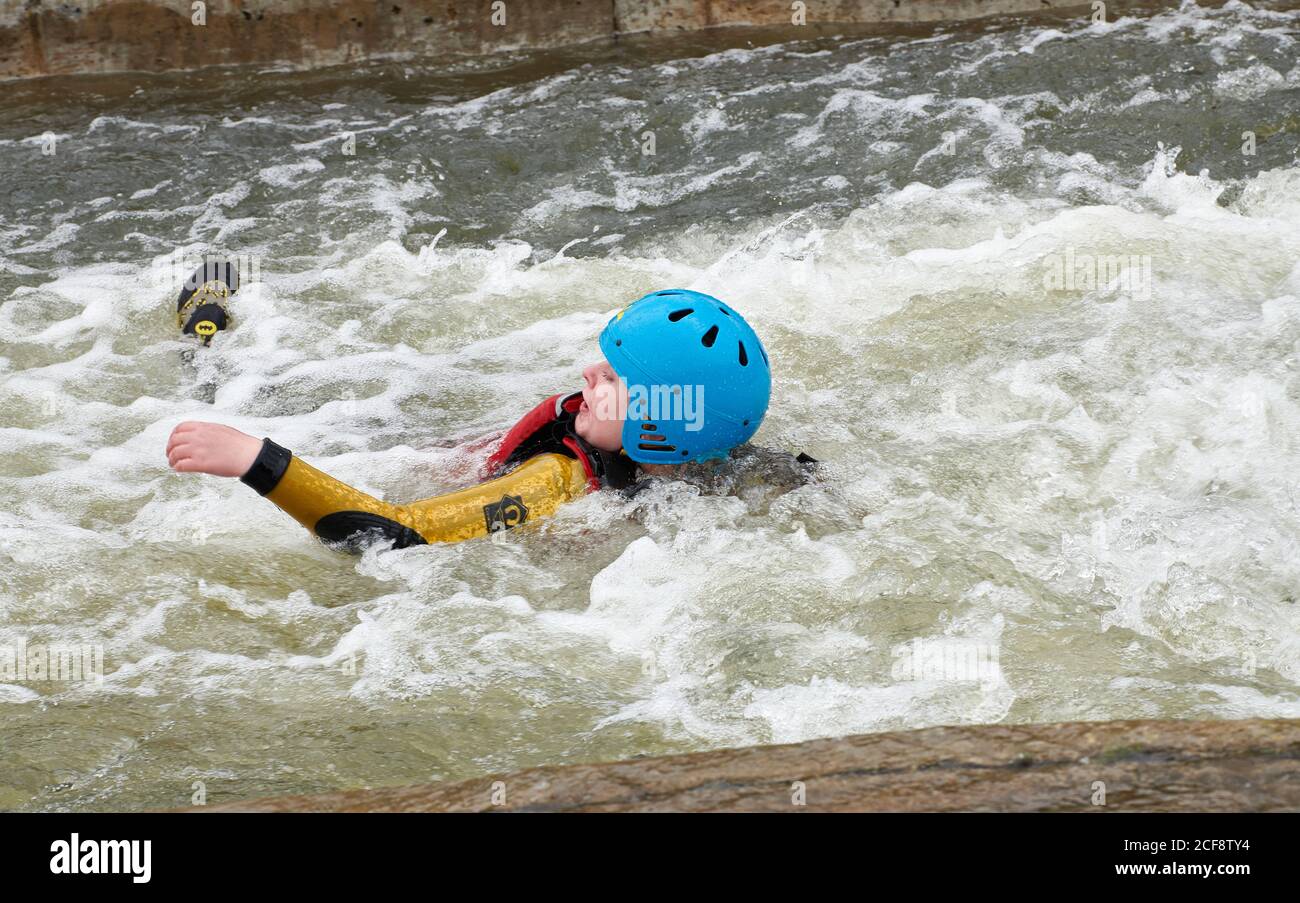An adolescent girl floats downstream on her back through a stopper at