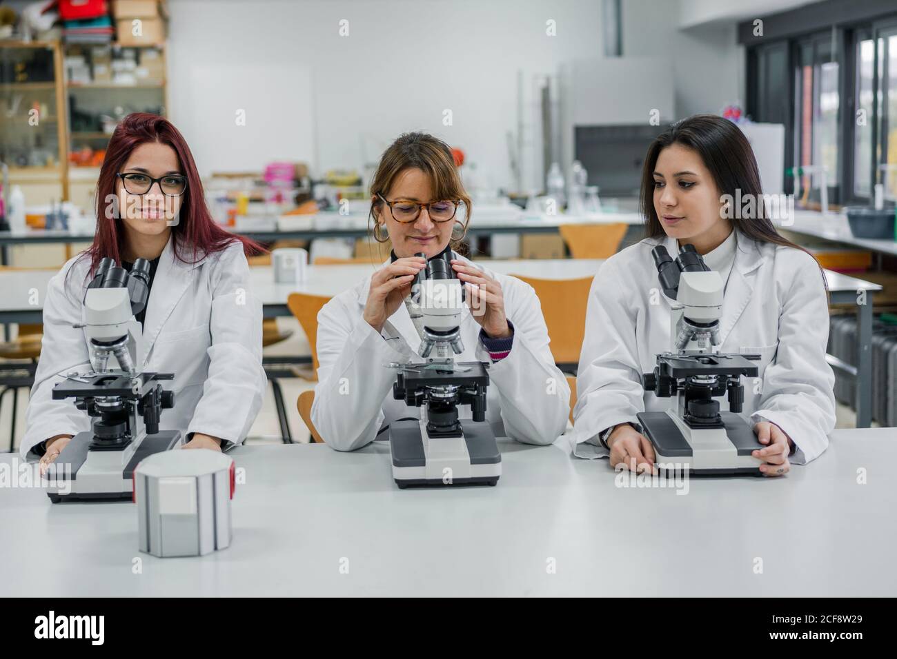 Female scientists using microscopes in lab Stock Photo Alamy