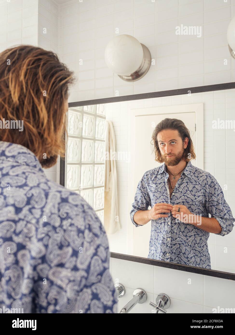 Handsome male checking hairstyle in mirror reflection Stock Photo