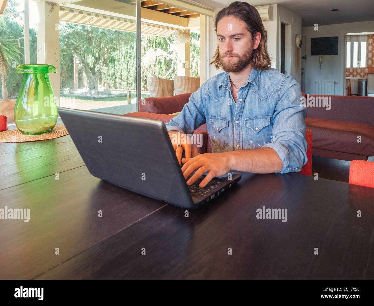 Focused man using computer in apartment Stock Photo