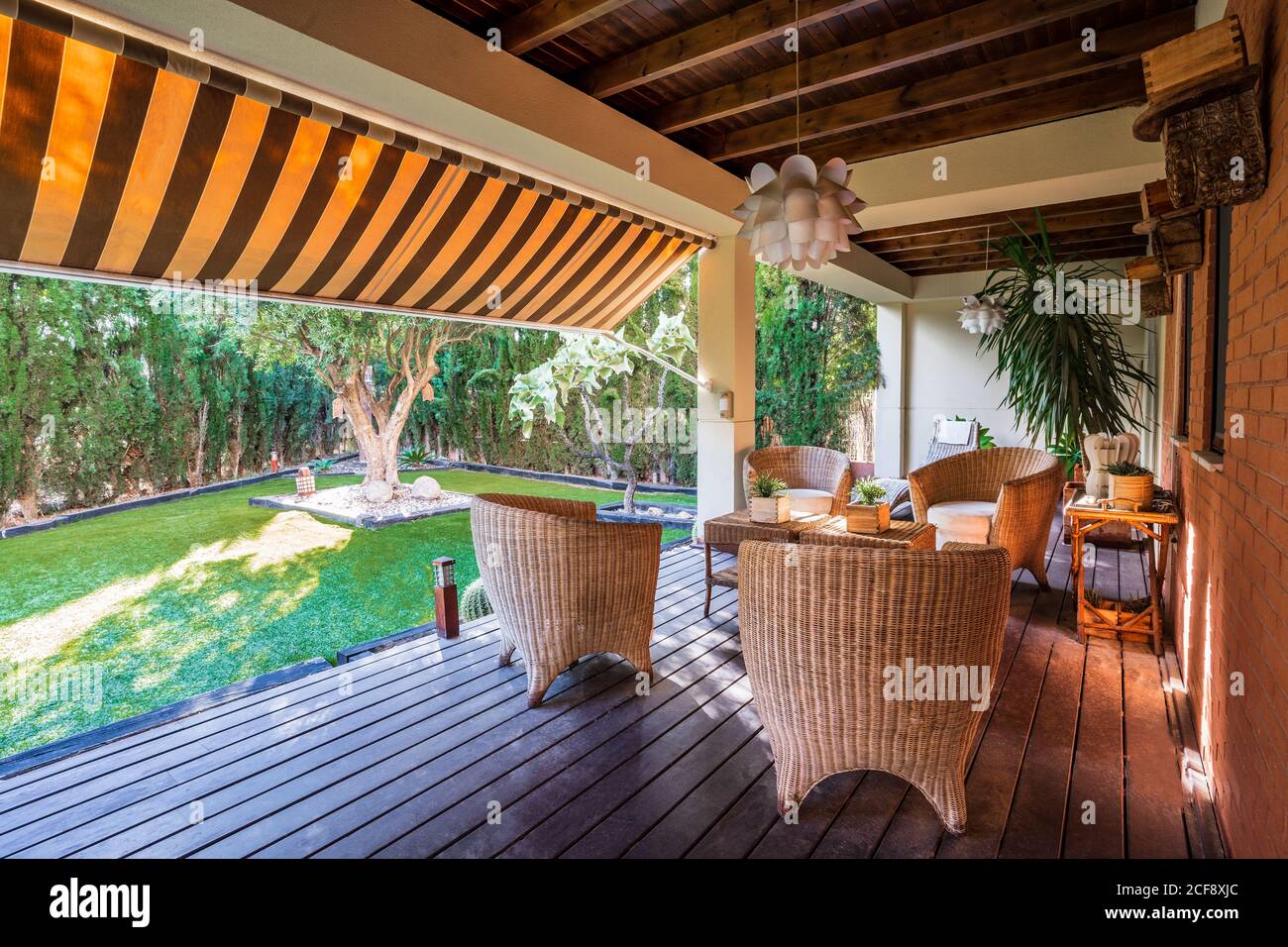 Wooden table with chairs placed on spacious garden terrace of modern ...