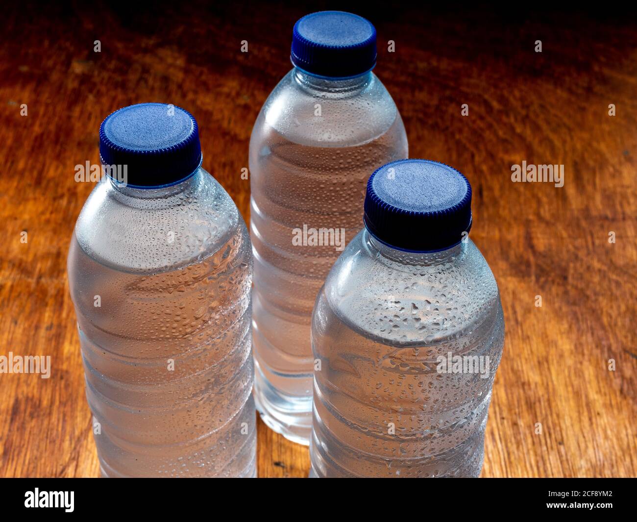 https://c8.alamy.com/comp/2CF8YM2/group-of-very-cold-water-bottles-with-blue-caps-and-water-drops-2CF8YM2.jpg