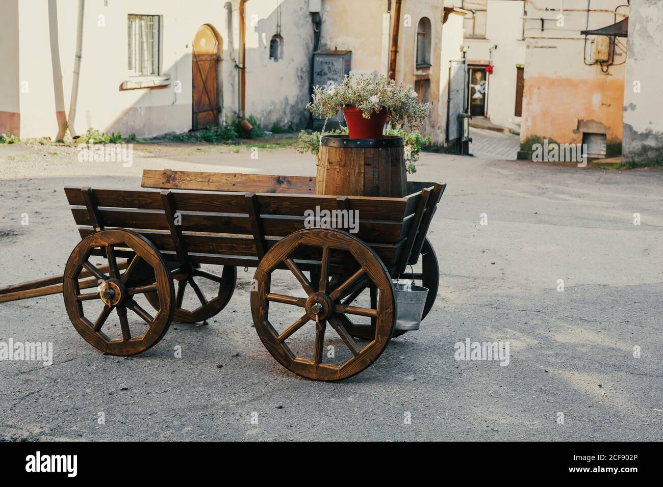 Wooden old-fashioned cart, decorative retro wagon in the yard, vintage stand for flowers, garden decor ideas Stock Photo