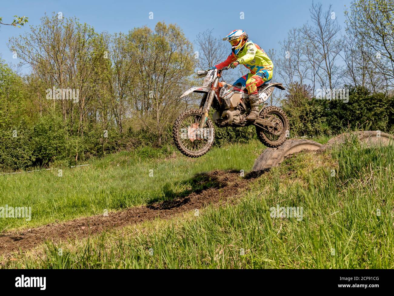 Biandronno, Lombardy, Italy - April 22, 2018: Motocross rider in jumping from the trampoline above the road. Open competitions in motocross. Stock Photo