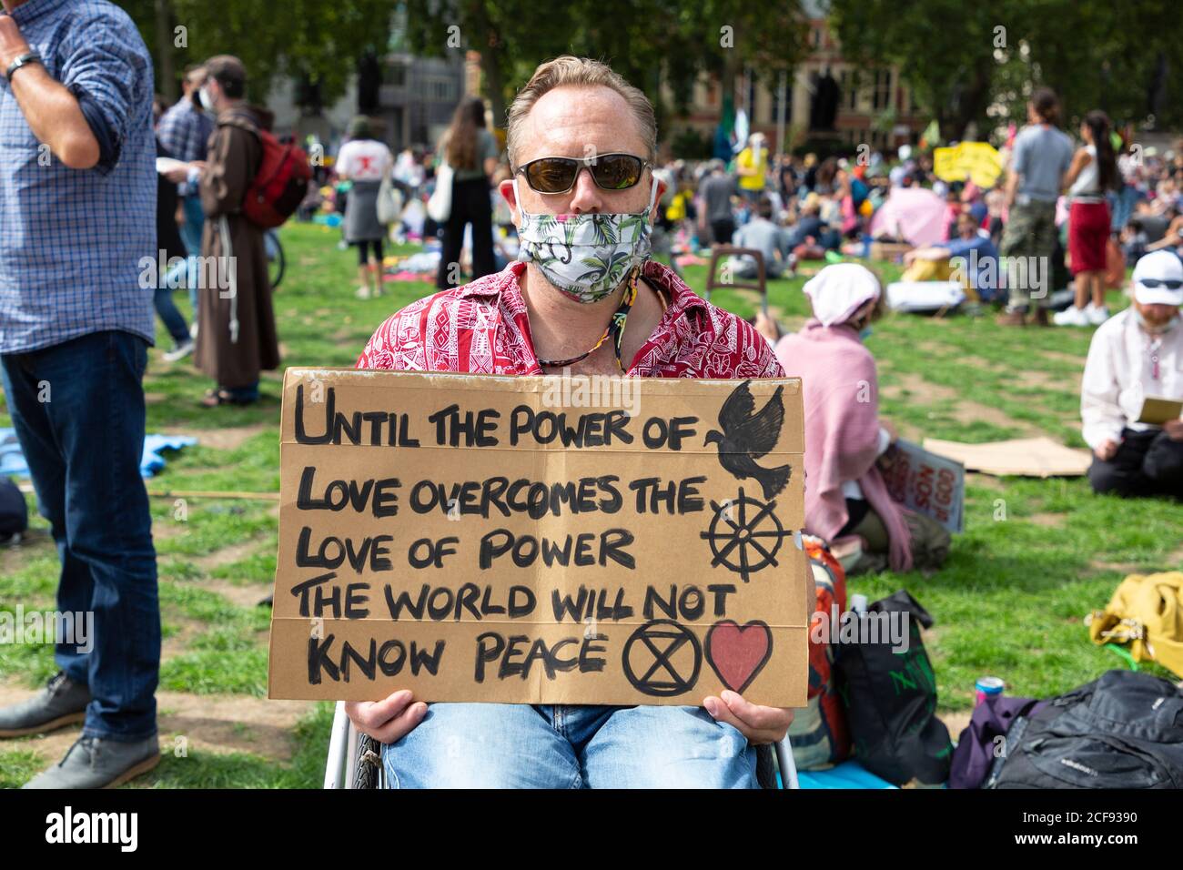 A protester on wheelchair holds up a sign during Extinction Rebellion demonstration, Parliament Square, London, 1 September 2020 Stock Photo