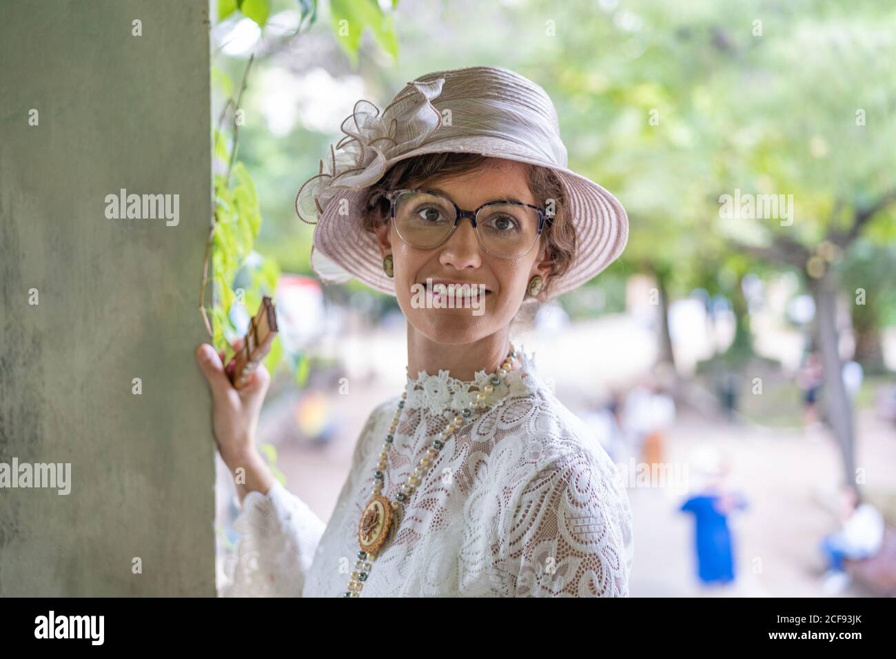 Smiling lady in vintage hat in garden Stock Photo