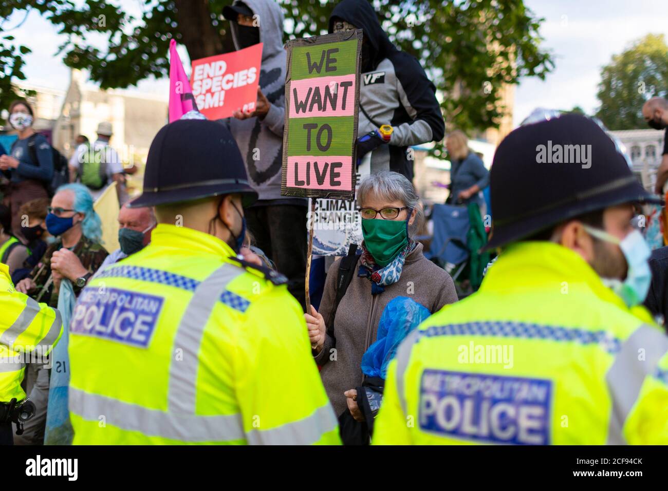 A protester holds up a sign to police officers during Extinction Rebellion demonstration, Parliament Square, London, 1 September 2020 Stock Photo