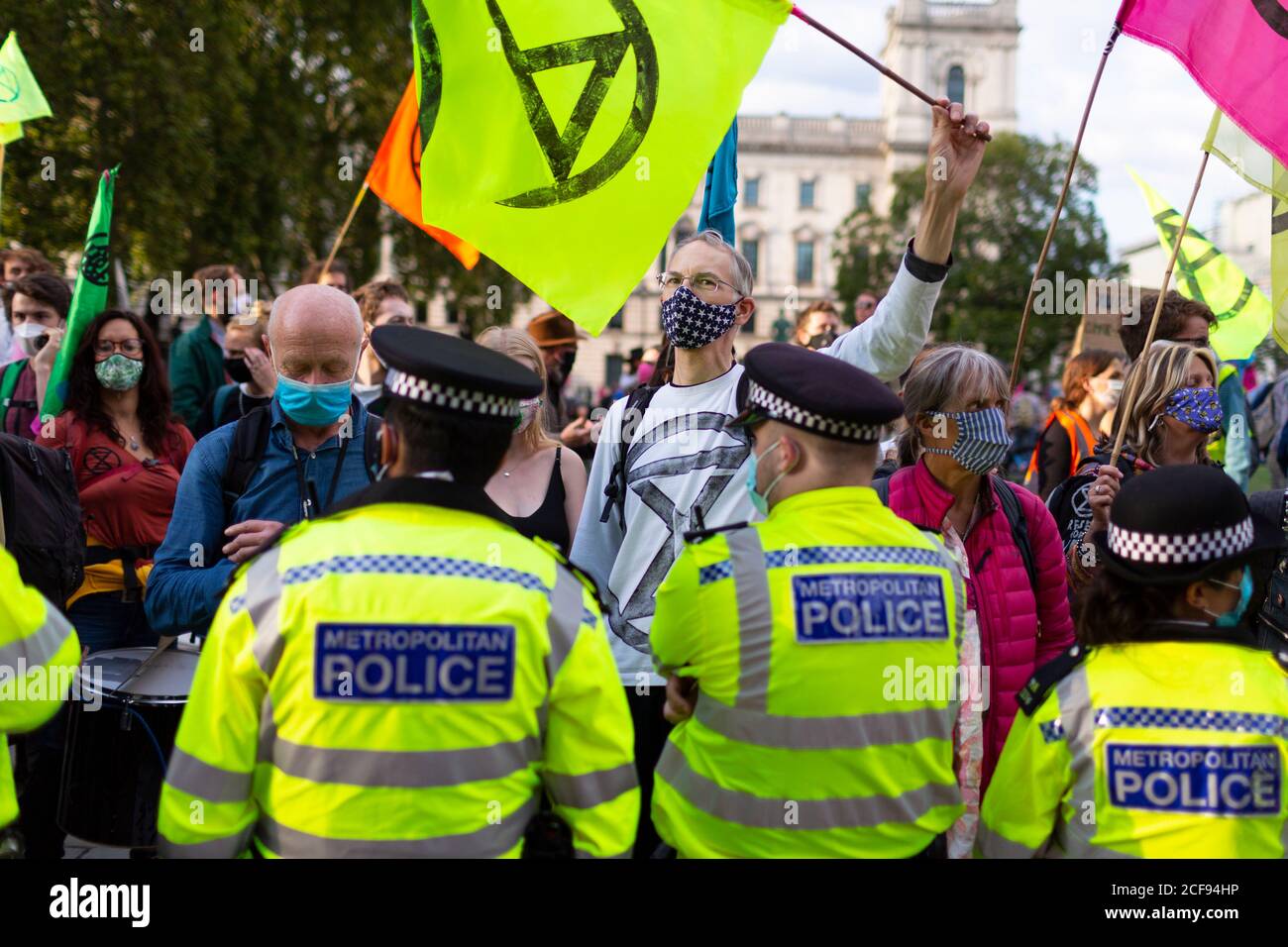 Protesters wave flags in front of police during Extinction Rebellion demonstration, Parliament Square, London, 1 September 2020 Stock Photo