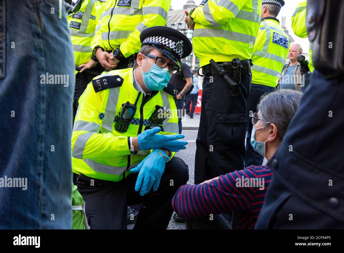A police officer talks to protester blocking road during Extinction Rebellion demonstration, Parliament Square, London, 1 September 2020 Stock Photo