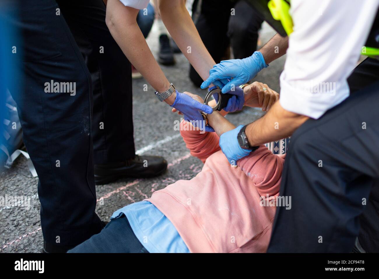 Police officers place handcuffs on a protester blocking road during Extinction Rebellion demonstration, London, 1 September 2020 Stock Photo