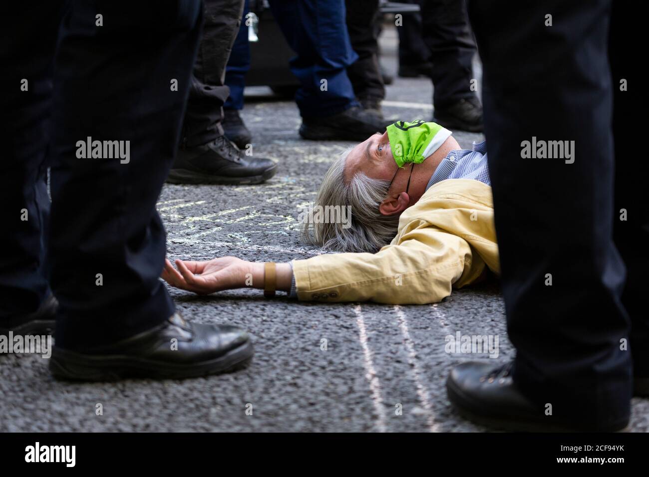 A protester lying on the road beneath police during Extinction Rebellion demonstration, Parliament Square, London, 1 September 2020 Stock Photo