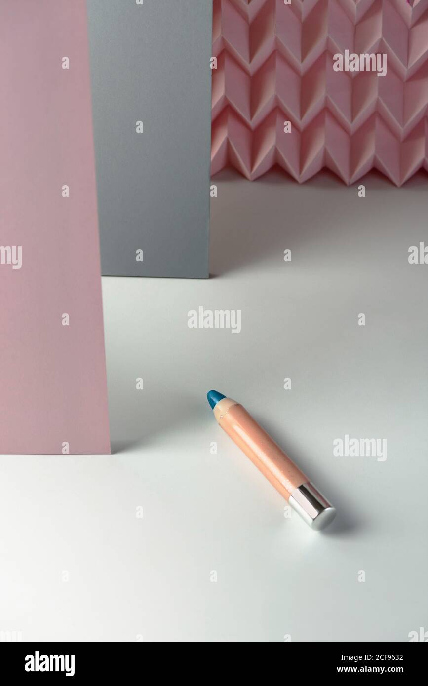 Cosmetic pencils:, make up blue eyeliner pencil, modern background with pink chevron reliefs. make up concept Stock Photo